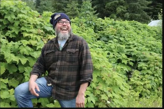 Luke Meyers, owner and guide of Wild Bear Safari, laughing outdoors in Hoonah, Alaska